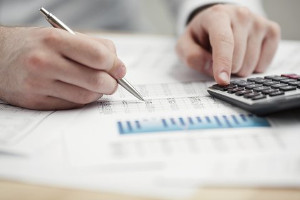 Hands of person using calculator